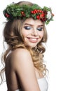 Lovely happy young smiling model woman with wavy blonde hair, makeup and green winter wreath posing isolated on white background Royalty Free Stock Photo