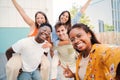 A lovely hispanic girl taking a selfie portrait with her multiracial teenage friends on piggybacks with cheerful Royalty Free Stock Photo