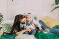 The lovely horizontal portrait of the woman hugging the little child while lying on the bed.