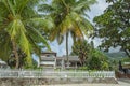 A lovely house between green palms and a white fence Royalty Free Stock Photo