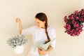 Lovely housewife with flower in pot and watering can. Royalty Free Stock Photo