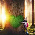 A lovely girl with backpack hugging a tree with heart shape Royalty Free Stock Photo