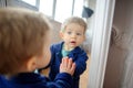 The lovely kid looks in a mirror. Royalty Free Stock Photo