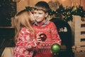 Lovely kiss. Cute little girl and boy play ornaments balls christmas tree. Kid enjoy winter holiday at home. Cozy