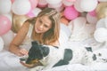 Lovely lady in pajama in bedroom play with her dog. Indoor portrait girl with baloons in morning. Husband surprising his wife