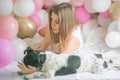 Lovely lady in pajama in bedroom play with her dog. Indoor portrait girl with baloons in morning. Husband surprising his wife