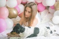 Lovely lady in pajama in bedroom play with her dog. Indoor portrait  girl with baloons in morning. Husband surprising his wife Royalty Free Stock Photo