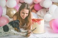 Lovely lady in pajama making selfie in her bedroom using phone with her dog. Indoor portrait  girl with baloons in morning. Royalty Free Stock Photo