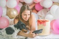 Lovely lady in pajama making selfie in her bedroom using phone with her dog. Indoor portrait  girl with baloons in morning. Royalty Free Stock Photo