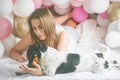 Lovely lady in pajama making selfie in her bedroom using phone with her dog. Indoor portrait  girl with baloons in morning. Royalty Free Stock Photo