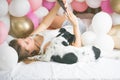 Lovely lady in pajama making selfie in her bedroom using phone and hanging out with her dog. Indoor portrait  girl with baloons in Royalty Free Stock Photo