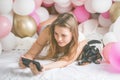 Lovely lady in pajama making selfie in her bedroom using phone and hug her dog. Indoor portrait  girl with baloons in morning. Royalty Free Stock Photo