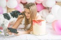 Lovely lady in pajama making selfie in her bedroom using phone and kiss  her dog. Indoor portrait  girl with baloons in morning. Royalty Free Stock Photo