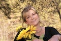 Lovely lady poses outdoors holding sunflowers