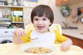 Lovely little boy eating soup with meat balls at home kitchen Royalty Free Stock Photo