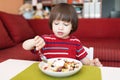 Lovely little boy eats fruit salad