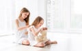 Lovely little girl brushing hair of younger sister