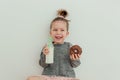 Lovely little girl is eating chocolate donut with bottle of milk. Having fun, enjoing food. Sweets lover concept. Lifestyle Royalty Free Stock Photo