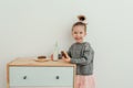 Lovely little girl is eating chocolate donut with bottle of milk. Portrait of cute stylish girl satisfied eating donuts. Sweets