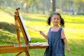 Lovely little girl show happy smile and enjoy with painting in the garden with morning light Royalty Free Stock Photo