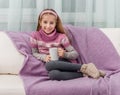 Lovely little girl on a sofa with warm blanket Royalty Free Stock Photo