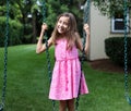 Lovely little girl at swings in the park with pink dress during summer in Michigan Royalty Free Stock Photo