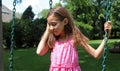 Lovely little girl at swings in the park with pink dress during summer in Michigan Royalty Free Stock Photo