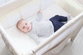 Lovely little 3 months baby lying in travel crib