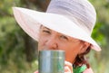 Lovely mature brunette cts in a lounge chair drinking coffee on a summer day.