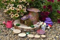 Funny fairy dollhouse on wooden planks by flowerbed with petunia flowers in the garden Royalty Free Stock Photo