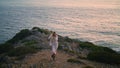 Lovely model climbing sea cliff alone. Blonde woman walking hill water horizon