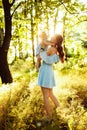 Lovely mother with adorable daughter walking at the park, smiling, caring woman hold cute baby girl in arms, enjoy