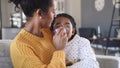 Lovely mother embracing daughter making inhalation with a nebulizer