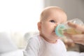 Lovely mother giving her baby drink from bottle Royalty Free Stock Photo