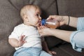 Lovely mother giving her baby drink juice from bottle Royalty Free Stock Photo