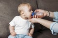 Lovely mother giving her baby drink juice from bottle Royalty Free Stock Photo