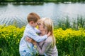 Lovely mother kissing her son in summer meadow