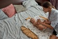 Mother interacting with infant baby indoors in bedroom Royalty Free Stock Photo