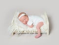 Lovely newborn baby sleeping on crib with leg on the floor Royalty Free Stock Photo