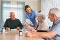 Lovely nurse giving medicine to senior woman at care facility Royalty Free Stock Photo