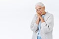 Lovely old lady with grey combed hair, in glasses lean face on palms and gazing camera sad or lonely, feeling frustrated Royalty Free Stock Photo