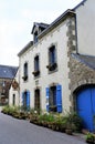 Lovely old stone house with blue wooden window shutters in Brittany France Europe Royalty Free Stock Photo