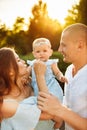 Lovely parents with little baby girl at the park, loving mom and dad play with cute daughter, smiling, pretty woman hold Royalty Free Stock Photo