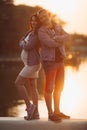 Lovely parents standing near lake and posing together