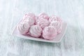 Lovely pastel rose meringues, zephyrs, marshmallows on the wooden vintage table