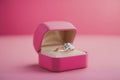 A pink gift box and engagement gold ring on a pink background