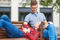 Lovely portrait of a young couple. They are sitting on the bench, embracing and kissing Royalty Free Stock Photo