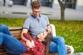 Lovely portrait of a young couple. They are sitting on the bench, embracing and kissing. Royalty Free Stock Photo