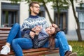 Lovely portrait of a young couple. They are sitting on the bench, embracing and kissing Royalty Free Stock Photo