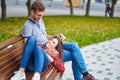 Lovely portrait of a young couple. They are sitting on the bench, embracing and kissing Royalty Free Stock Photo